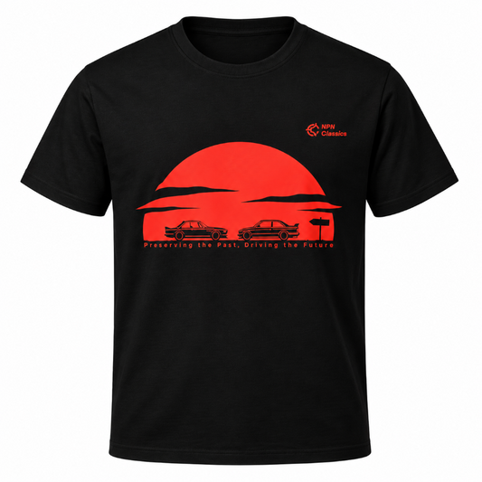 A black short-sleeve crewneck t-shirt featuring a red graphic print of two classic BMW cars in front of a large red sun, with the text 'Preserving the Past, Driving the Future' and a small NPN Classics logo on the upper left chest.
